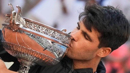 El español Carlos Alcaraz besa el trofeo tras ganar la final masculina del Abierto de Francia de tenis contra el alemán Alexander Zverev en el estadio Roland Garros de París, Francia, el domingo 9 de junio (AP)