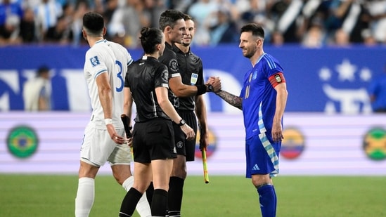 El delantero argentino Lionel Messi, derecha, estrecha la mano de los árbitros. (AP)