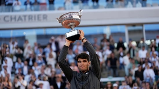 El ganador español Carlos Alcaraz celebra con el trofeo su victoria en el partido final masculino del Abierto de Francia contra el alemán Alexander Zverev en el estadio Roland Garros de París (AP)