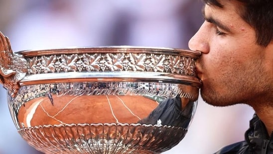 El español Carlos Alcaraz besa el trofeo tras ganar el Abierto de Francia.