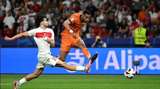 El holandés Cody Gakpo (d) supera con un disparo al turco Ferdi Kadioglu durante el partido de cuartos de final de la Eurocopa 2024 en Berlín. (AFP)