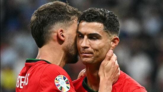 El portugués Cristiano Ronaldo es consolado por Ruben Dias durante la victoria de su equipo sobre Eslovenia en los octavos de final de la Eurocopa 2024. (AFP)