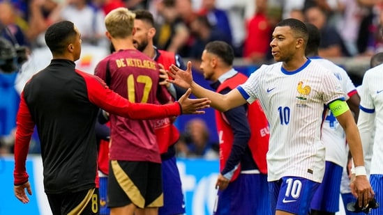 El francés Kylian Mbappé, a la derecha, es recibido por el belga Youri Tielemans al final de un partido de octavos de final entre Francia y Bélgica en la Eurocopa 2024 (AP)