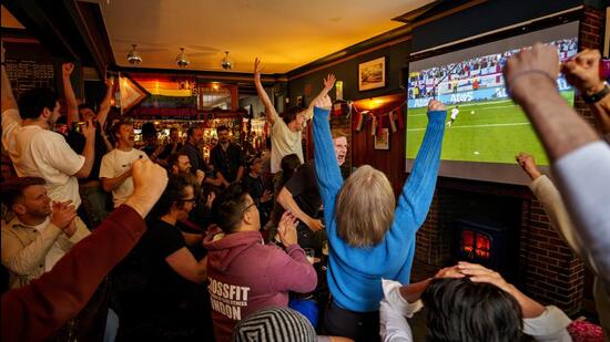 Los aficionados reaccionan cuando el portero inglés Jordan Pickford ataja un penal durante la tanda de penaltis contra Suiza el sábado. (AP)