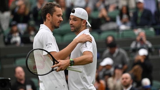 El búlgaro Grigor Dimitrov (derecha) es consolado por el ruso Daniil Medvedev después de retirarse de su partido de tenis de cuarta ronda individual masculino en el séptimo día del Campeonato de Wimbledon 2024 en el All England Lawn Tennis and Croquet Club en Wimbledon, suroeste de Londres, el 7 de julio de 2024. (Foto de ANDREJ ISAKOVIC / AFP) / RESTRINGIDO AL USO EDITORIAL (AFP)