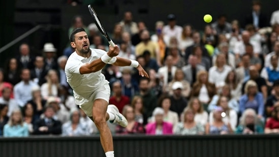 El serbio Novak Djokovic devuelve la pelota al danés Holger Rune durante su partido de tenis individual masculino en el octavo día del Campeonato de Wimbledon 2024 (AFP)