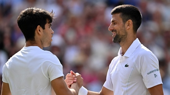 El español Carlos Alcaraz (izq.) y el serbio Novak Djokovic (der.) se dan la mano al final de la final individual masculina de Wimbledon (AFP)