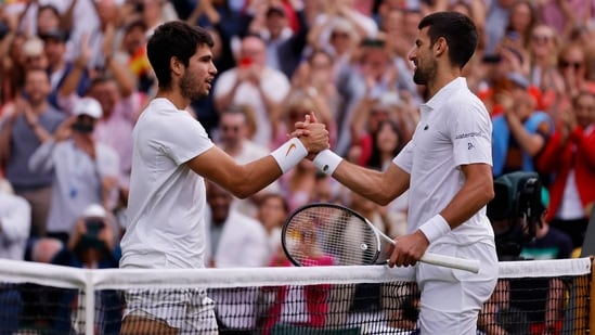El español Carlos Alcaraz (izquierda) con el serbio Novak Djokovic después de ganar la final de Wimbledon.(REUTERS)