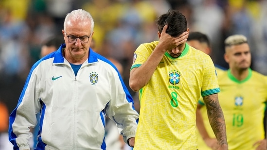 El entrenador de Brasil, Dorival Junior, a la derecha, escolta fuera del campo a Lucas Paqueta (8) y sus compañeros de equipo después de su derrota en la tanda de penaltis contra Uruguay durante un partido de cuartos de final de la Copa América en Las Vegas, el sábado (AP)