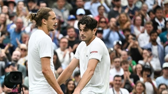 Taylor Fritz (derecha) habla con el alemán Alexander Zverev al final de su partido de tenis individual masculino (AFP)