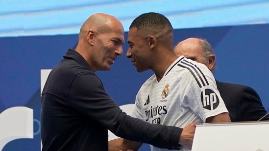 Kylian Mbappé, de Francia, abraza a la leyenda francesa Zinedine Zidane, a la izquierda, mientras es presentado a los fanáticos como nuevo jugador del Real Madrid en el Santiago Bernabéu (AP)