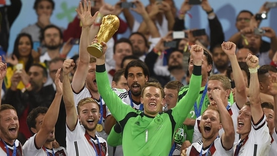 El portero alemán Manuel Neuer (delante en el centro) y sus compañeros celebran con el trofeo de la Copa Mundial 2014. (AFP)