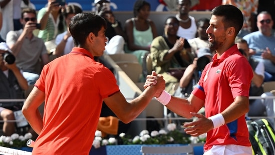 Novak Djokovic de Serbia (d) estrecha la mano de Carlos Alcaraz de España (i).(EPA-EFE)