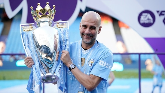 El entrenador del Manchester City, Pep Guardiola, celebra con el trofeo de la Premier League. (AP)