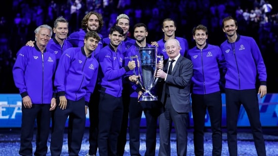   El ex tenista australiano Rod Laver (3d) sostiene el trofeo mientras posa con el capitán del equipo europeo Bjorn Borg (izq.), el griego Stefanos Tsitsipas (4d.), el español Carlos Alcaraz (5d.), el búlgaro Grigor Dimitrov (5d.), el alemán Alexander Zverev (4d.), el ruso Daniil Medvedev (der.) y otros jugadores del equipo europeo (AFP)