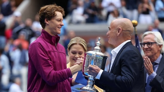 El ex tenista Andre Agassi entrega el trofeo al italiano Jannik Sinner. (REUTERS)