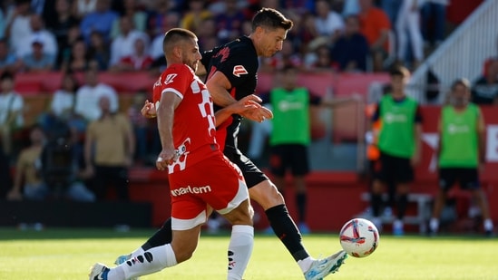 Robert Lewandowski del Barcelona, ​​a la derecha, disputa el balón con David López del Girona.(AP)