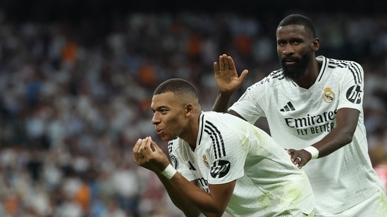 El delantero francés #09 del Real Madrid, Kylian Mbappé, celebra con el defensa alemán #22 del Real Madrid, Antonio Ruediger, después de marcar el primer gol de su equipo durante el partido de fútbol de la primera jornada de la primera ronda de la UEFA Champions League entre el Real Madrid CF y el Stuttgart VFB (AFP)