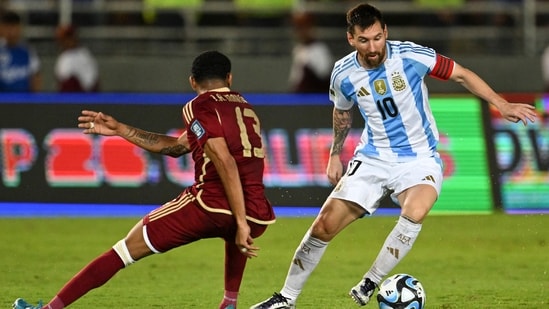 El delantero argentino Lionel Messi (dcha.) y el centrocampista venezolano José Martínez pelean por el balón. (AFP)