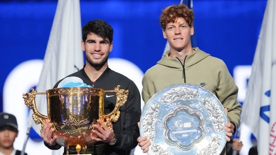 El español Carlos Alcaraz, izquierda, posa con su trofeo tras ganar al italiano Jannik Sinner, derecha, durante el partido de la final individual masculina del Abierto de China. (AP)