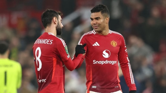 El centrocampista portugués del Manchester United #08 Bruno Fernandes (i) celebra con el centrocampista brasileño del Manchester United #18 Casemiro (AFP)