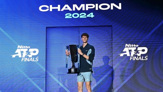 El italiano Jannik Sinner posa con el trofeo tras ganar la final contra el estadounidense Taylor Fritz en el torneo de tenis ATP Finals en Turín el 17 de noviembre de 2024 (AFP)