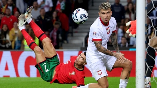 El portugués Cristiano Ronaldo, izquierda, anota el quinto gol de su equipo con un puntapié durante el partido de fútbol de la Liga de Naciones de la UEFA entre Portugal y Polonia en el estadio Dragao de Oporto, Portugal. (AP)