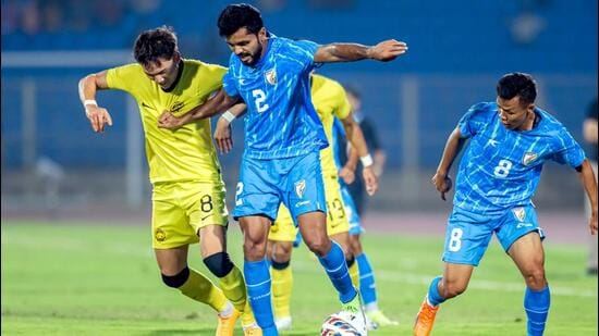 Los jugadores de India y Malasia compiten por el balón en su amistoso internacional de fútbol en Hyderabad el lunes. (PTI)