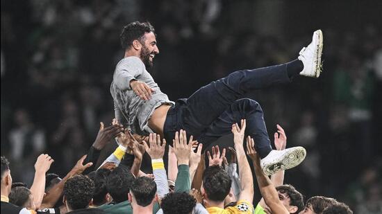 El entrenador portugués del Sporting de Lisboa, Rubén Amorim, es celebrado por sus jugadores tras vencer al Man City el martes. (AFP)