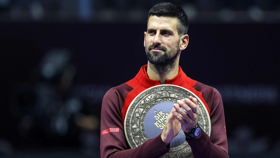 El serbio Novak Djokovic aplaude con un trofeo.(AFP)