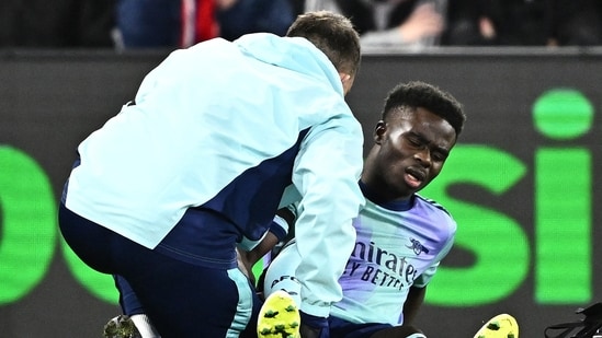 Bukayo Saka del Arsenal recibe atención médica tras sufrir una lesión.(REUTERS)