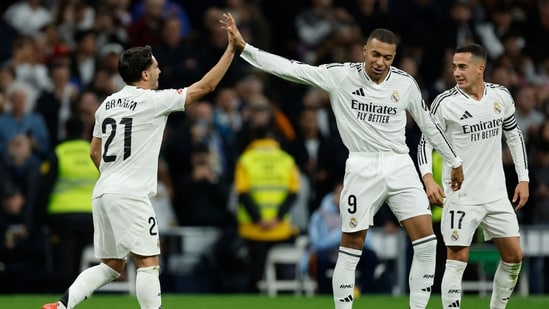 TOPSHOT - El delantero marroquí del Real Madrid #21 Brahim Diaz (L) celebra con el delantero francés del Real Madrid #09 Kylian Mbappé anotando el cuarto gol de su equipo durante el partido de fútbol de la liga española entre el Real Madrid CF y el Sevilla FC en el estadio Santiago Bernabeu de Madrid en diciembre 22 de diciembre de 2024. (Foto de OSCAR DEL POZO / AFP)(AFP)